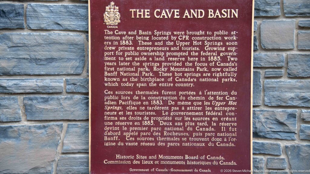 Close view of the bilingual Cave and Basin plaque describing the springs and early national park history.