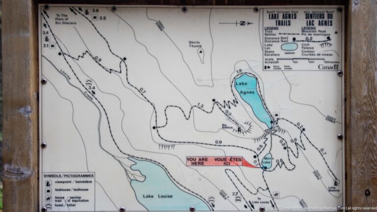 A bilingual trail map marks Mirror Lake and routes to Lake Agnes, Little Beehive, and the Plain of Six Glaciers.