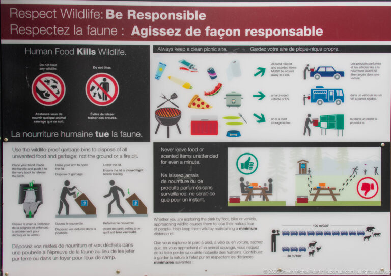 Bilingual wildlife-safety panel with diagrams about food storage, garbage disposal, picnicking, and keeping campsites clean.