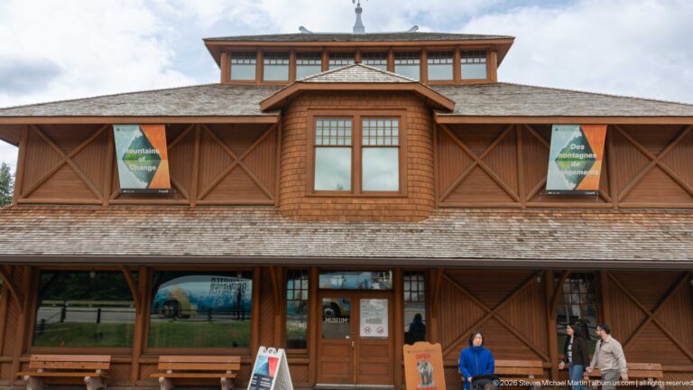 Front façade of Banff Park Museum with central bay, clerestory windows, shingled roof, and timber bracing.