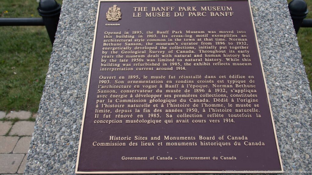 Bronze bilingual historic plaque for the Banff Park Museum mounted on a stone pedestal.