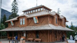 Corner view of the timber Banff Park Museum with shingled roof, veranda, diagonal bracing, and clerestory.