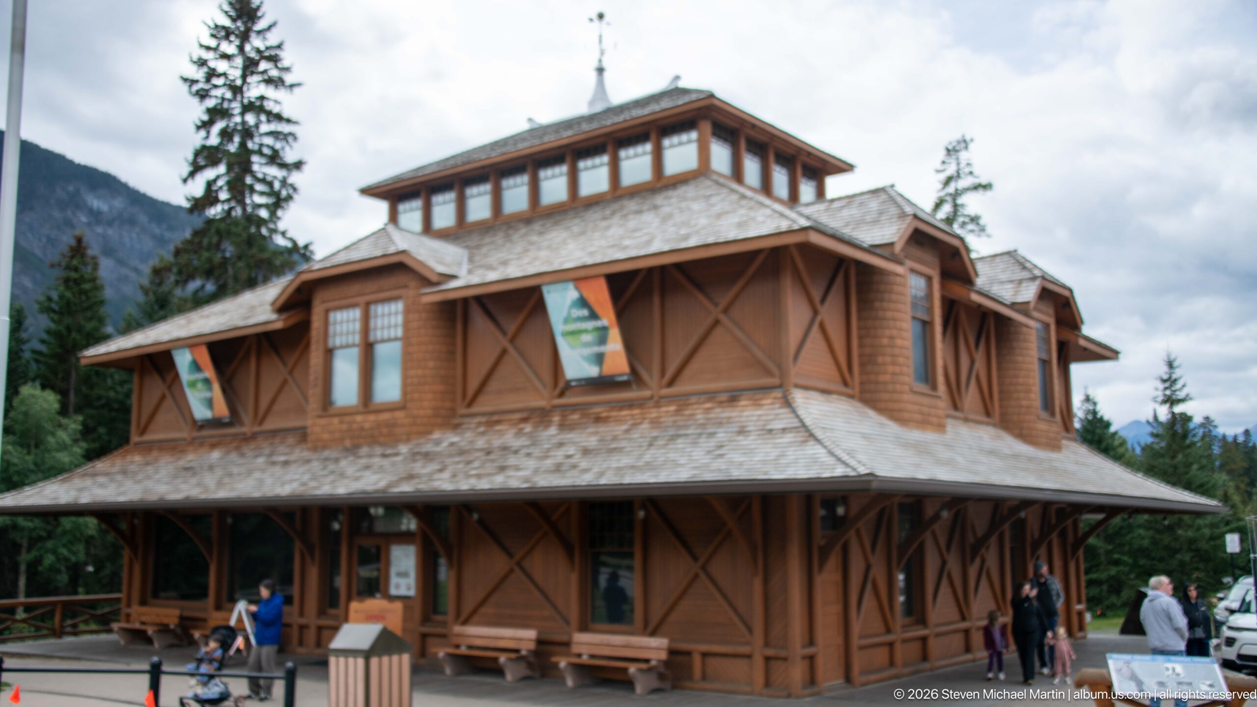 Corner view of the timber Banff Park Museum with shingled roof, veranda, diagonal bracing, and clerestory.