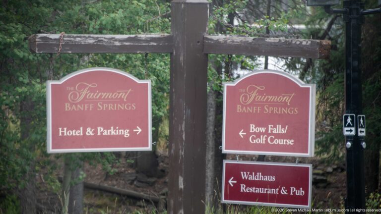 Red Fairmont Banff Springs directional signs point toward the hotel, Bow Falls, golf course, and Waldhaus Restaurant & Pub.