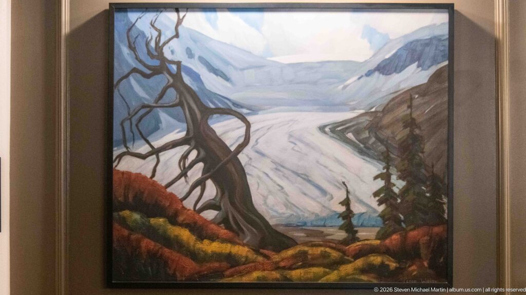 Framed painting of a curving glacier in a mountain valley, bordered by dark conifers, a bare tree, and autumn-colored ground.