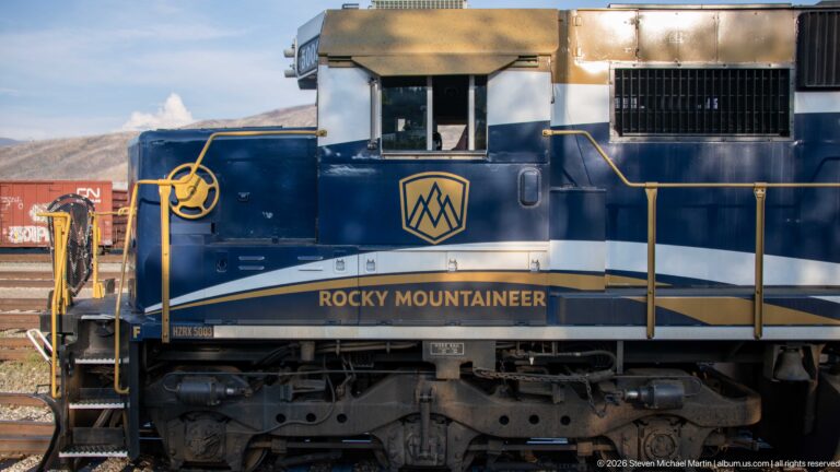 Side detail of Rocky Mountaineer locomotive 5003 showing cab, mountain logo, handrails, and running gear.