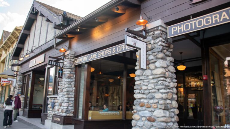 Fieldstone and timber entrance to Harmony Lane Shops & Offices with projecting retail signs.