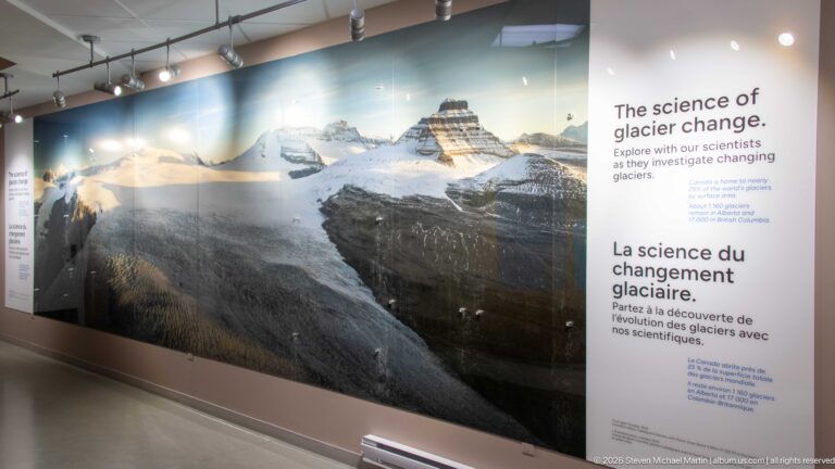 Wall-size mountain photograph beside bilingual text titled The Science of Glacier Change.
