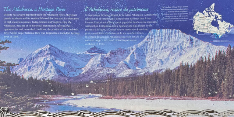 Blue interpretive panel with a mountain river photograph, bilingual text, and a watershed map at upper right.
