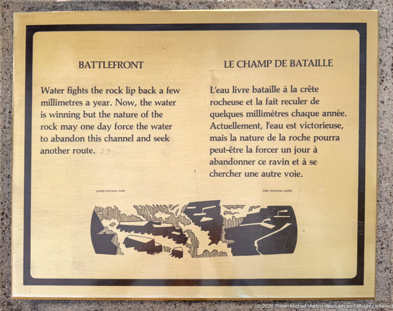 Tan bilingual “Battlefront” sign with text about water eroding the rock lip and a black-and-white channel diagram.