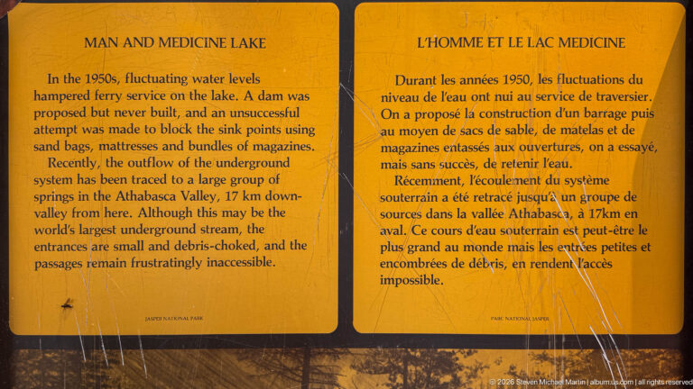 Bilingual yellow interpretive panel headed Medicine Lake explains fluctuating water levels, sink points, and underground drainage toward the Athabasca Valley