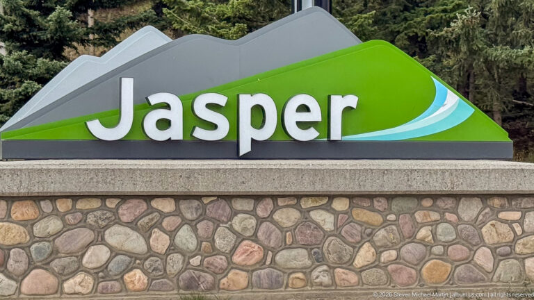 Large green-and-gray Jasper wordmark mounted above a rounded-stone masonry base