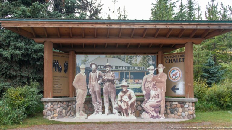 A roofed interpretive panel uses historic figures and photographs to present Maligne Lake Chalet history