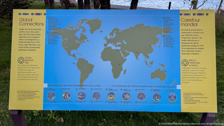 Bilingual World Heritage interpretive panel with a large world map, marked locations, and a row of circular images along the bottom.