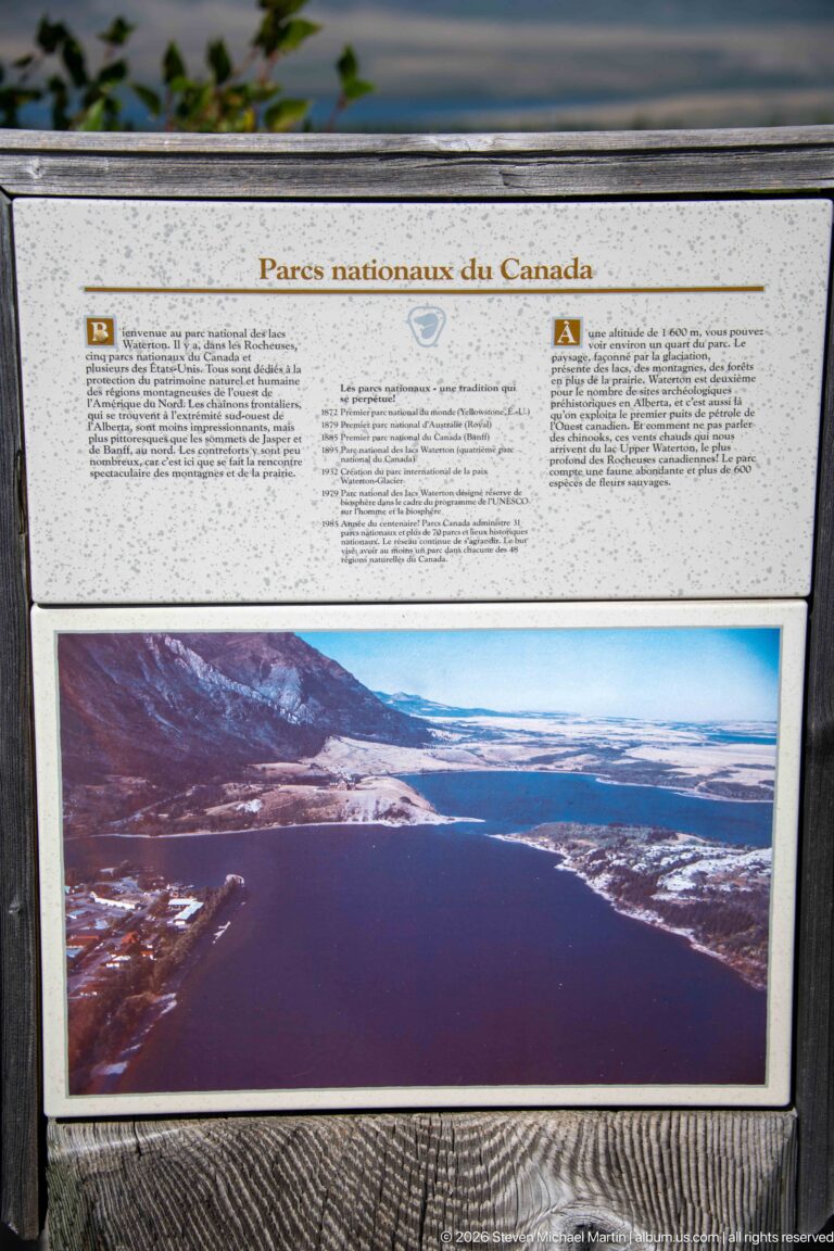 Bilingual Parks Canada interpretive panel about a national peace park above a panoramic photograph of a mountain lake.