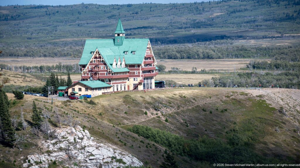 Prince of Wales Hotel with steep green roofs, central tower, and red-and-cream façades standing on an open bluff.