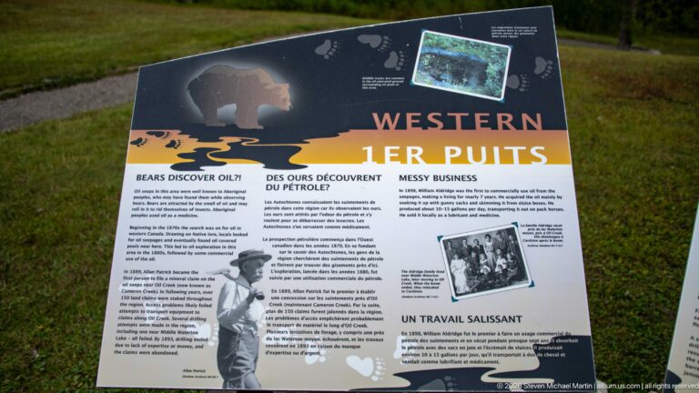 Bilingual Western interpretive panel with a bear graphic, archival photographs, and sections about early petroleum exploration.