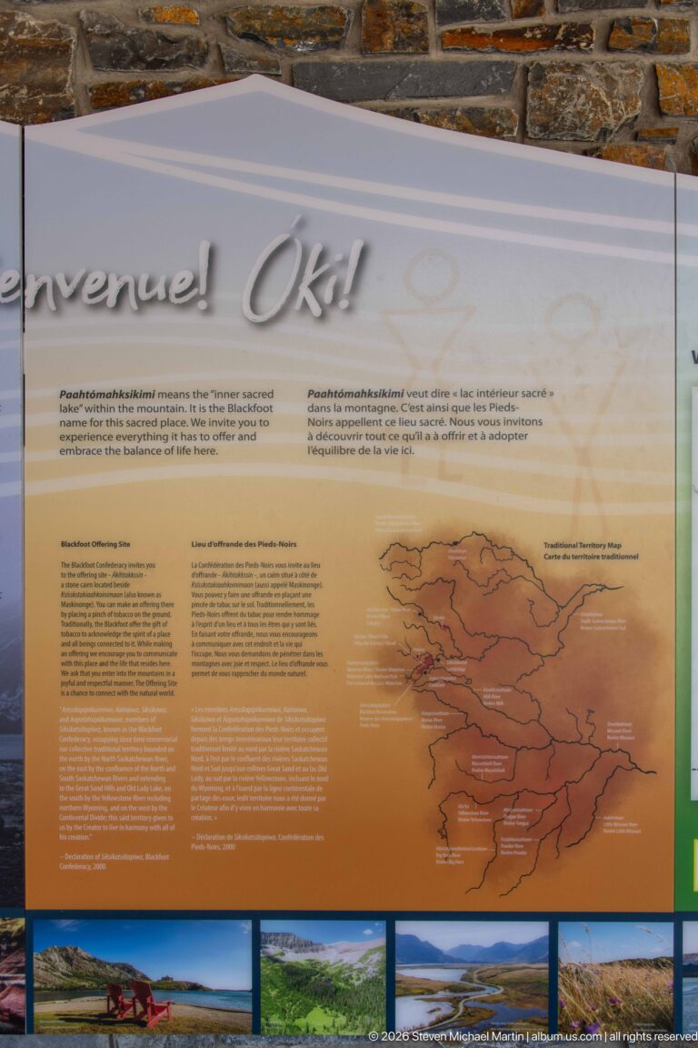 Orange bilingual interpretive panel with branching Waterton watershed diagram and landscape photographs along bottom.