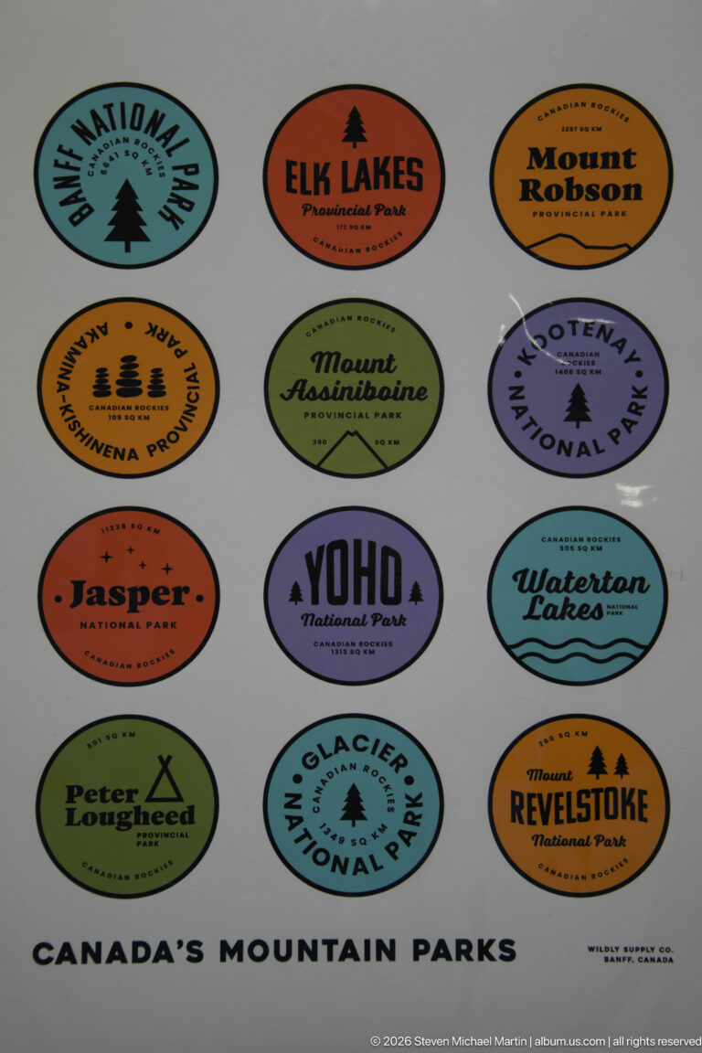 Poster with colorful oval travel badges for Canada's mountain parks, including Waterton Lakes, Banff, Jasper, Yoho, and Glacier.